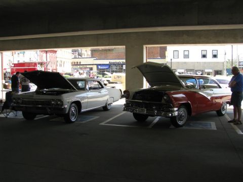 2003 Mercury Marauder - Two vintage cars are displayed with their hoods open in a parking garage.