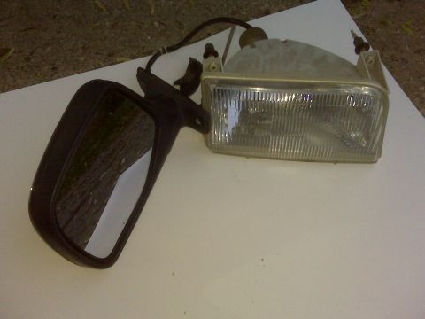 1995 Ford Bronco - A side mirror and headlight assembly are shown on a white surface.