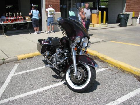 2003 Mercury Marauder - A maroon touring motorcycle is parked in a lot with trophies on a table in the background.