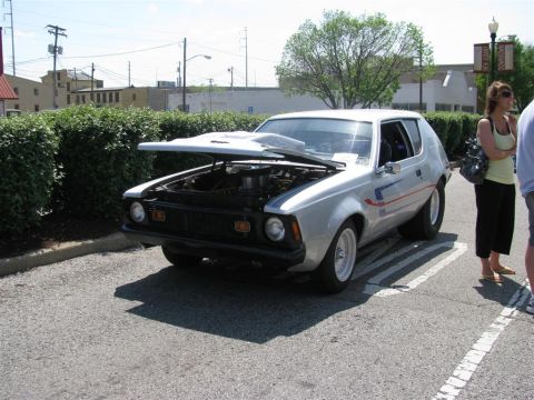 2003 Mercury Marauder - A silver AMC Gremlin is parked with its hood open, revealing the engine compartment.