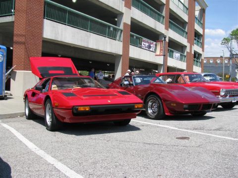 2003 Mercury Marauder - A red sports car is parked with its hood open at an outdoor car show.