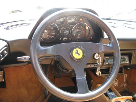 2003 Mercury Marauder - The interior of a Ferrari features a leather-wrapped steering wheel with the iconic prancing horse emblem and a set of analog gauges.