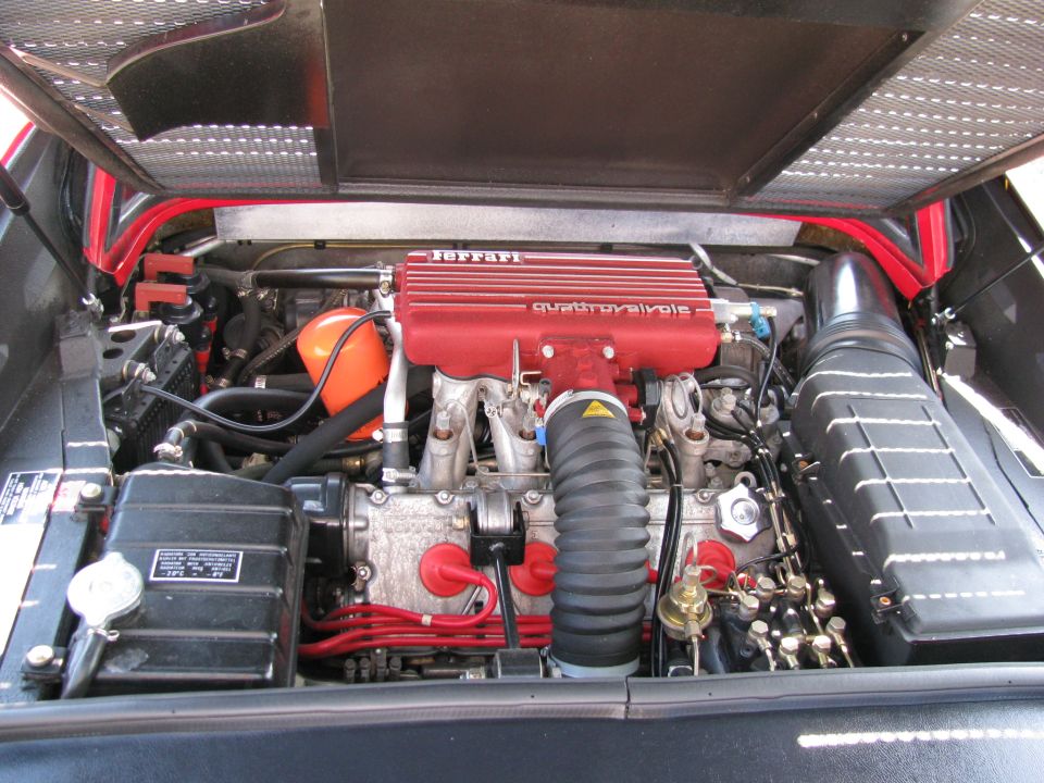Engine bay with red Ferrari intake manifold labeled "QUATTROVALVOLE"