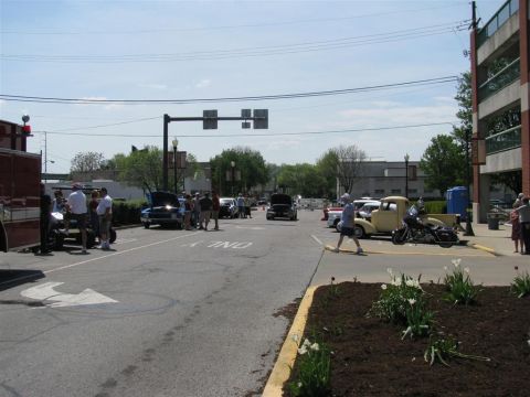 2003 Mercury Marauder - A street scene shows a gathering of people and various vehicles, including a motorcycle and a yellow pickup truck.
