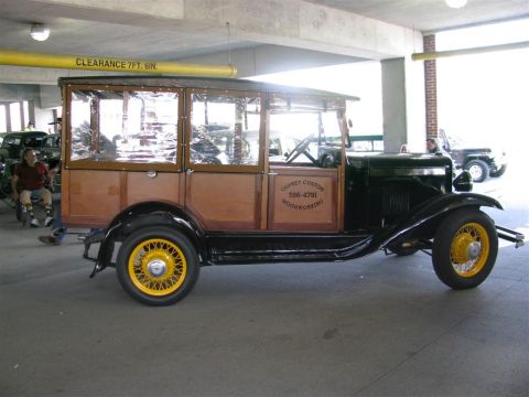 2003 Mercury Marauder - A vintage wood-paneled station wagon is parked indoors, with other vehicles visible in the background.