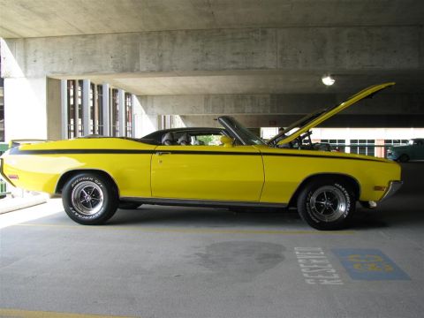 2003 Mercury Marauder - A yellow convertible with black racing stripes is parked with its hood open.