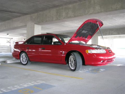 2003 Mercury Marauder - A red sedan is parked in a garage with its hood open, revealing the engine bay.