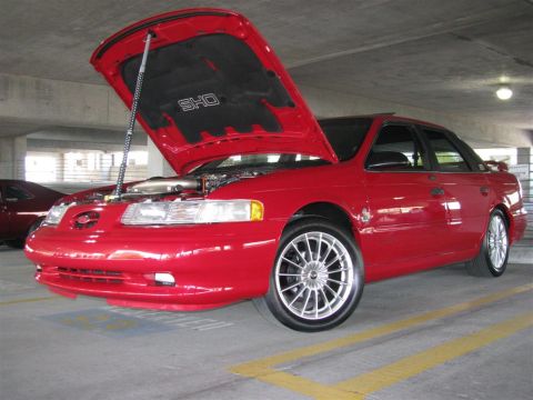 2003 Mercury Marauder - Red sedan, possibly a Ford Taurus SHO, parked in a garage with its hood open.