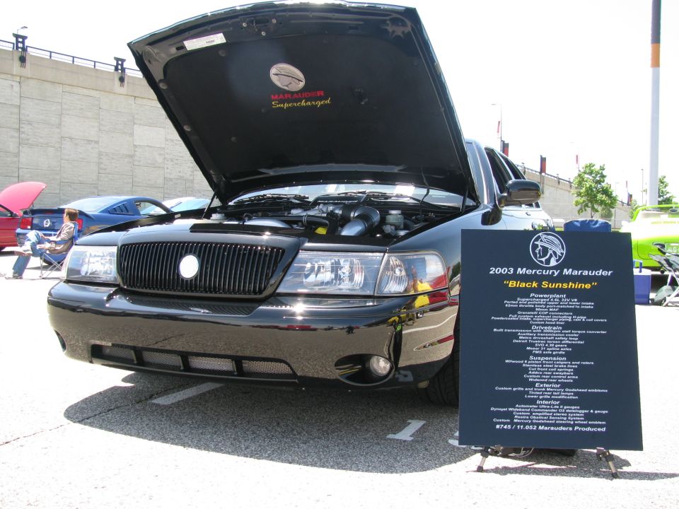 Black 2003 Mercury Marauder with hood open, parked at a car show