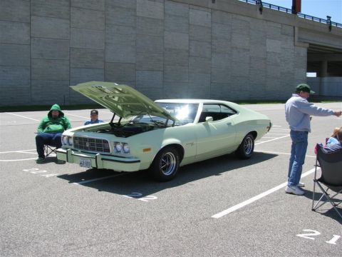 2003 Mercury Marauder - A light green 1970s Ford Gran Torino is parked with its hood up at an outdoor event.