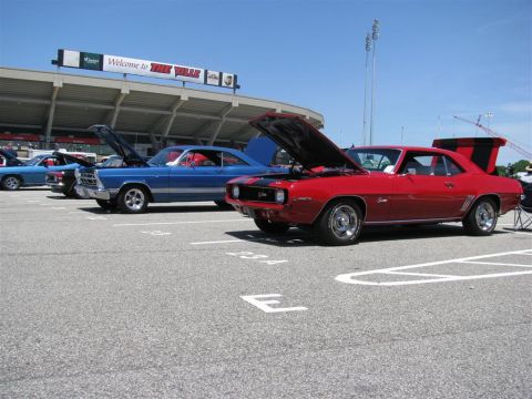 2003 Mercury Marauder - Two classic cars, a red Camaro and a blue sedan, are parked at an outdoor event.