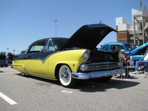 2003 Mercury Marauder - A yellow and black 1955 Ford Fairlane Crown Victoria is displayed with its hood open at an outdoor event.