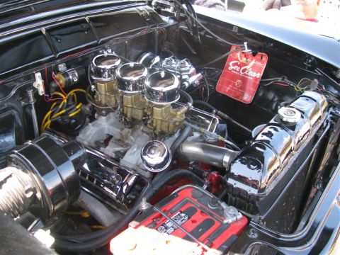 2003 Mercury Marauder - The engine bay features a triple carburetor setup and a prominent red battery.