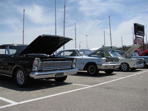 2003 Mercury Marauder - Several classic cars are parked in a lot with their hoods open under a partly cloudy sky.