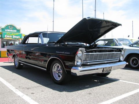 2003 Mercury Marauder - A black 1966 Ford Galaxie 500 convertible is displayed with its hood open at a car show.