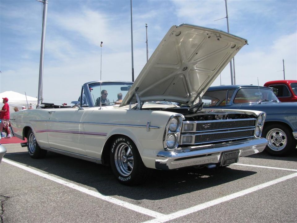 White 1965 convertible with hood open, parked next to a blue car