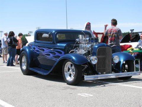 2003 Mercury Marauder - A blue hot rod with custom flame paint is displayed at an outdoor event.
