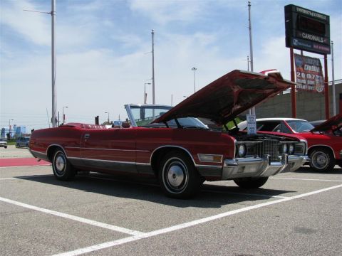 2003 Mercury Marauder - Two red cars, one a convertible with its hood open, are parked at an outdoor event.