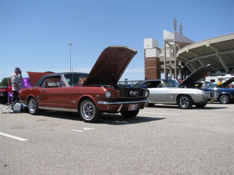 2003 Mercury Marauder - Several classic cars are displayed with their hoods up at an outdoor event, with stadium seating in the background.