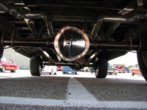 2003 Mercury Marauder - A low-angle shot reveals the polished rear differential and custom exhaust pipes of a vehicle at a car show.