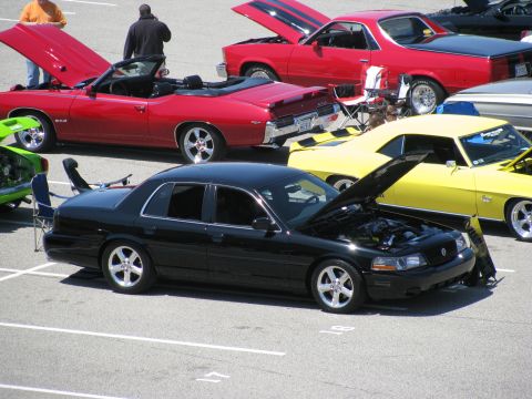 2003 Mercury Marauder - A black 2003 Mercury Marauder is displayed at a car show with its hood open, alongside other cars.