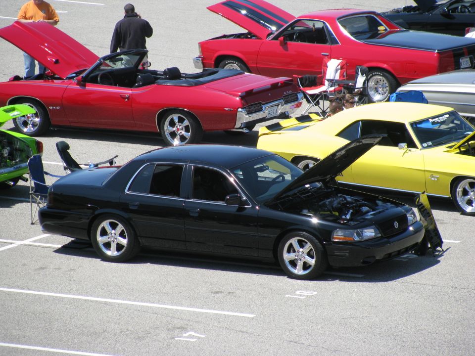Black 2003 Mercury Marauder with hood open, parked at a car show with other vehicles