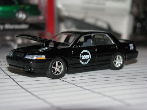 2003 Mercury Marauder - A black diecast car with its hood open is displayed, a '2009' badge on the side.