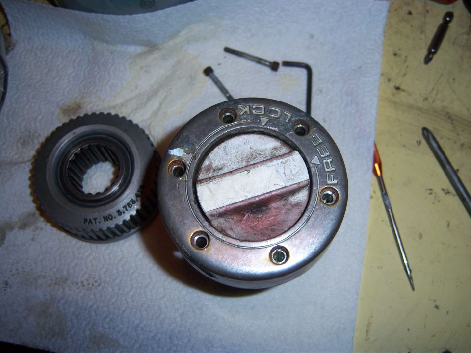 Manual locking hub with 'LOCK' and 'FREE' markings next to a gear labeled 'PAT. NO. 3.788.411'. Tools are also visible