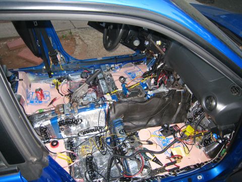 2007 Subaru Impreza - Car interior undergoing sound deadening and wiring modifications, with components removed.