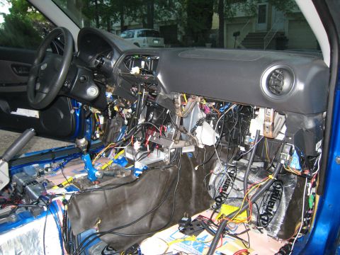 2007 Subaru Impreza - The interior of a blue car is disassembled, revealing complex wiring and sound dampening material.