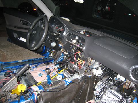 2007 Subaru Impreza - The interior of a 2007 Subaru Impreza is shown with the dashboard disassembled, revealing complex wiring and insulation.