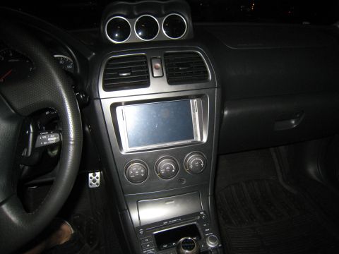 2007 Subaru Impreza - The interior of a Subaru Impreza shows a custom stereo system and triple gauges mounted on the dash.