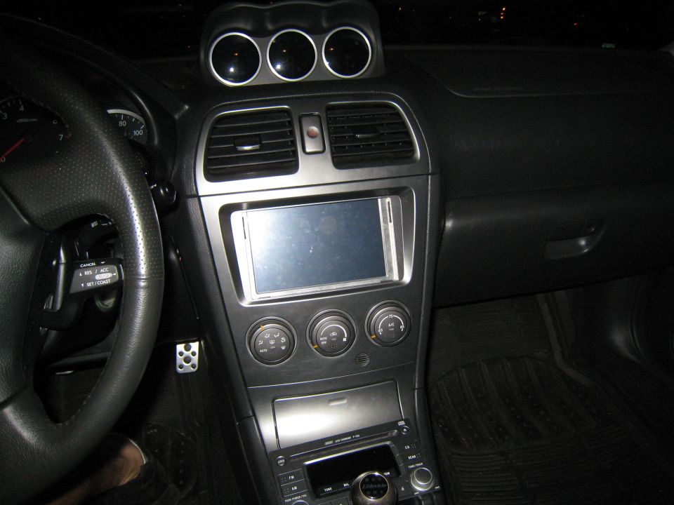 Dashboard of a 2007 Subaru Impreza with a touchscreen stereo and three gauges above the vents