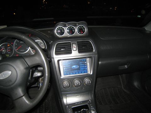 2007 Subaru Impreza - The interior of a 2007 Subaru Impreza shows a custom dashboard setup with aftermarket gauges and a modern infotainment system.