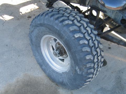 1962 Toyota Land Cruiser - A close-up view of a off-road tire and wheel assembly, highlighting its aggressive tread pattern.