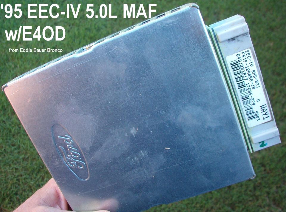 Ford EEC-IV engine control module held in hand over grass