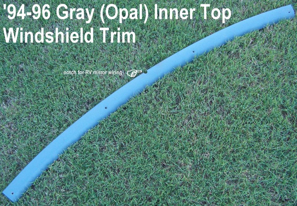 Gray curved inner top windshield trim piece on grass