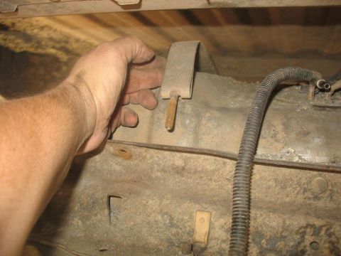 1987 Ford Bronco - Close-up of a fuel pump bracket and hose, likely from the underside of a vehicle.