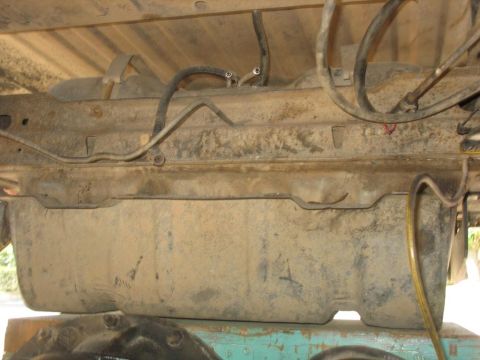 1987 Ford Bronco - The fuel tank and associated lines are visible from underneath the vehicle.