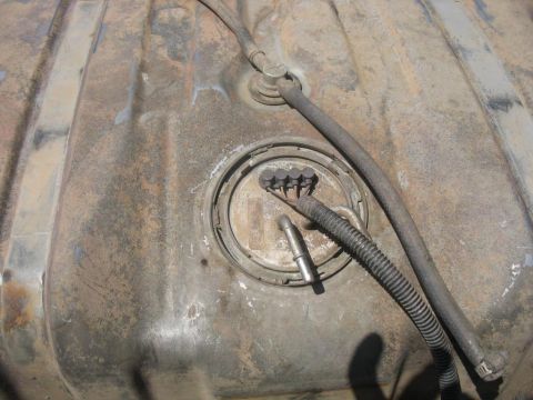 1987 Ford Bronco - Close-up of a weathered fuel tank sending unit, showing its internal components and connections.