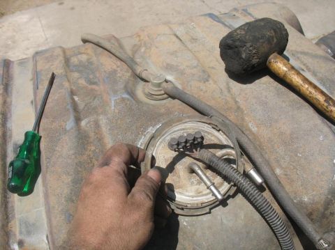 1987 Ford Bronco - Removing the fuel pump assembly from a vehicle's gas tank with tools.