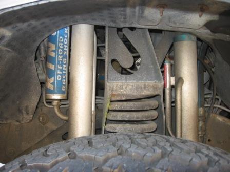 1984 Ford Bronco - Close-up view of off-road racing shock absorbers and suspension components on a vehicle.