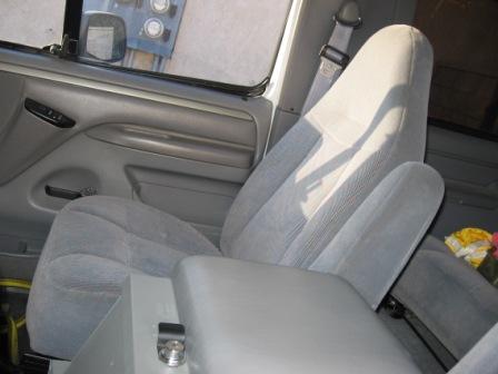1984 Ford Bronco - Interior view of a vehicle's passenger side, cloth seats and door panel.