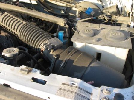1984 Ford Bronco - Close-up view of the engine compartment, focusing on the air intake system and fluid reservoirs.