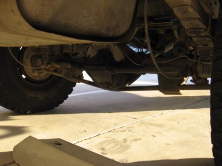 1984 Ford Bronco - Underside view of a vehicle's rear axle and suspension system.