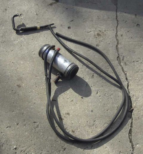 1997 Ford Taurus - A PCV catch can and associated hoses are laid out on a concrete surface.
