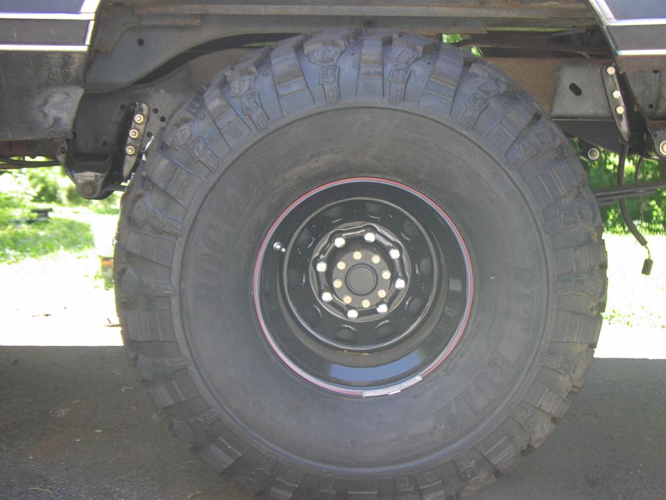 Tire and suspension components of a large vehicle, possibly a truck or SUV