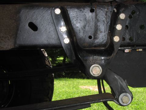 1986 Ford Bronco - Close-up view of a vehicle's leaf spring hanger bracket, showing its bolted construction.