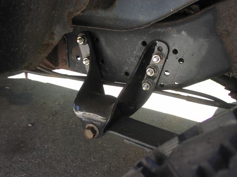 1986 Ford Bronco - Close-up of a vehicle's leaf spring hanger bracket attached to the frame.