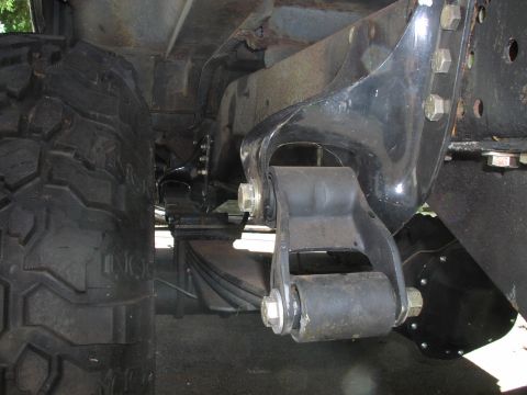 1986 Ford Bronco - This image shows the underside of a vehicle, focusing on the leaf spring and shackle assembly.